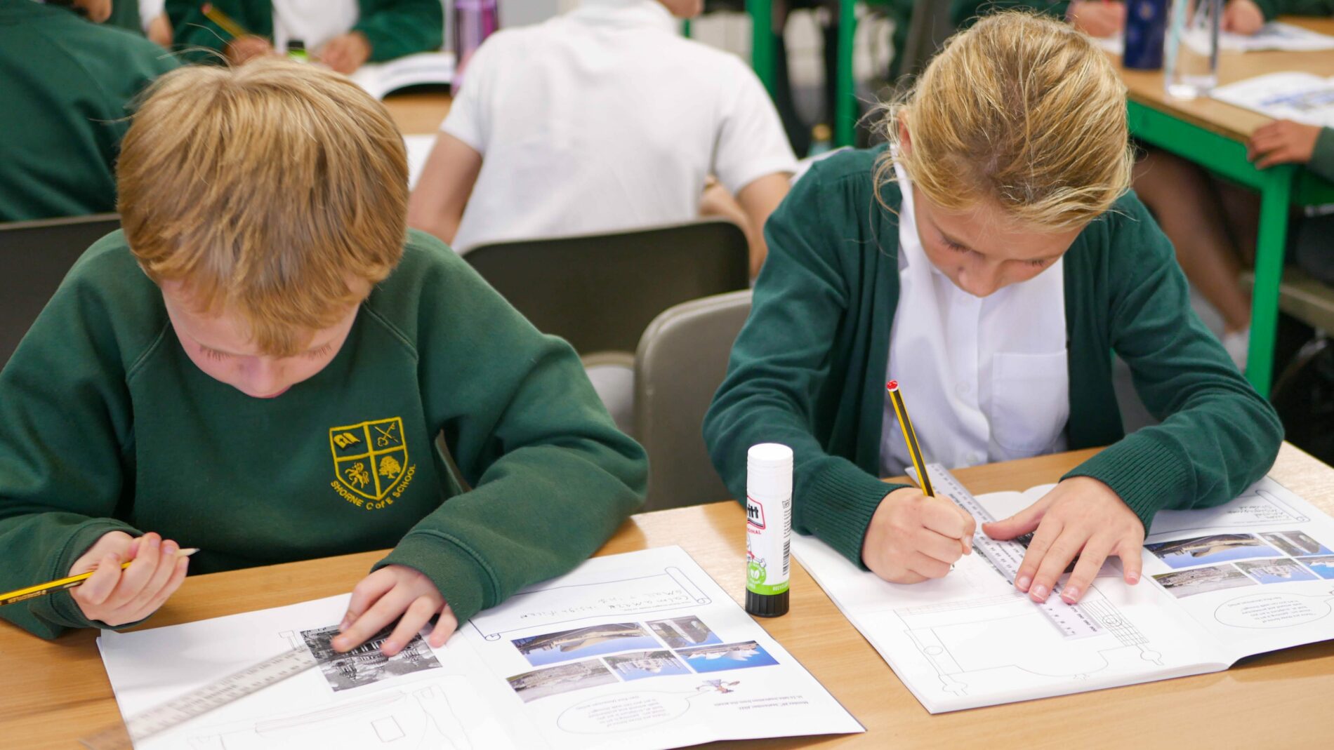 year 6 pupils learning how to draw buildings in art lesson