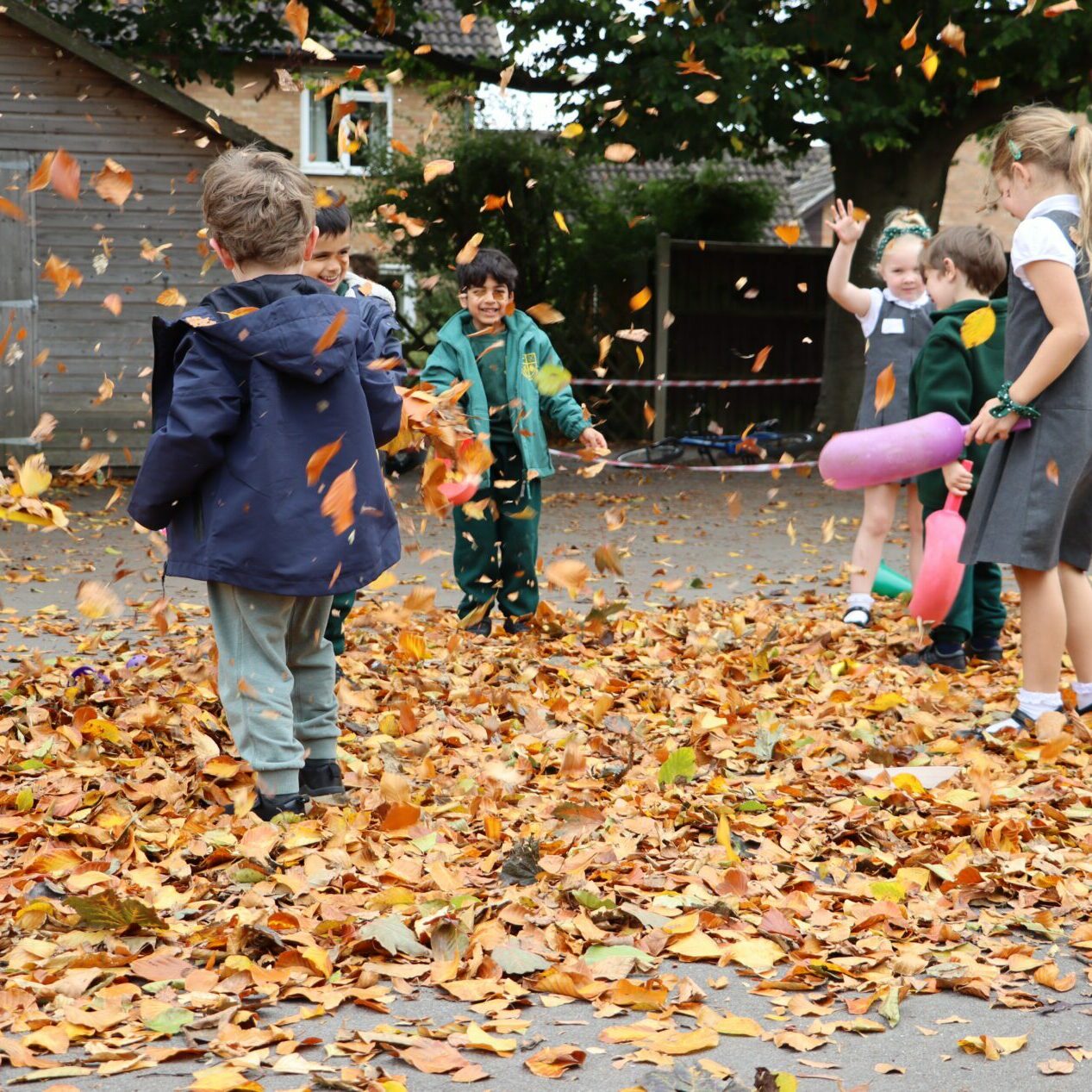 children playing in autumn weather in the playground at shorne primary school